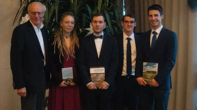 Prof. Heißenhuber mit den vier Preisträgern der besten Gesamtabschlüsse, sie halten Bücher mit landwirtschaftlichem Bezug