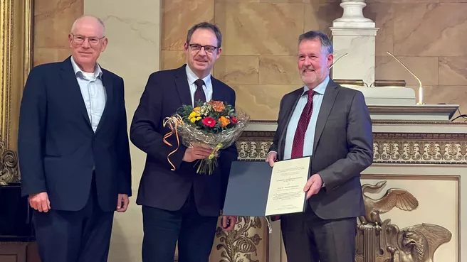 Bei der Preisverleihung: Dr. Bernhard Eckel (Kuratorium), Prof. Jürgen Hummel (Vorsitzender der Gesellschaft für Ernährungsphysiologie e.V. ) und Prof. Wilhelm Windisch stehen nebeneinander. Prof. Hummel hält einen Blumenstrauß, Prof. Windisch seine Urkunde.