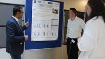 PhD Symposium: Three participants stand at the poster 